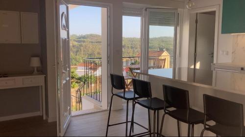 une cuisine avec des chaises et un comptoir avec un balcon dans l'établissement Casa da Ilha Granjal Treixedo, 