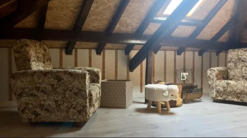 a living room with two chairs and a stuffed animal at Casa da Ilha Granjal Treixedo in Castelejo