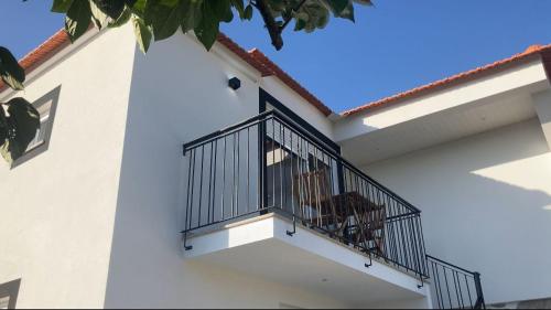 a balcony of a white building with two chairs on it at Casa da Ilha Granjal Treixedo in Castelejo
