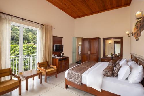 a bedroom with a large bed and a large window at Hotel Cassendra in Kandy