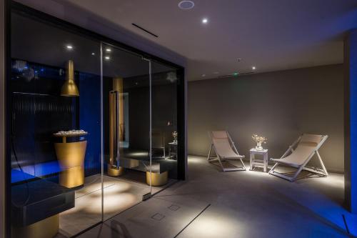 a room with two white chairs and a table at Ethereal White Resort Hotel & Spa - Adults Only in Heraklio Town