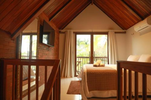 ein Schlafzimmer mit einem Bett in einem Zimmer mit einem Fenster in der Unterkunft Hotel Chale Lagoa Dos Ingas in Martins