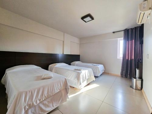 a hospital room with two beds and a window at CLH Suítes Foz do Iguaçu in Foz do Iguaçu