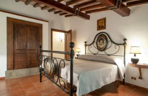 een slaapkamer met een bed en een houten deur bij Fattoria Uccelliera in Lorenzana
