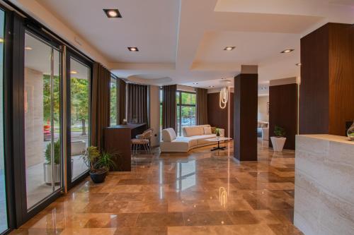 ein Wohnzimmer mit Glaswänden und eine Lobby in der Unterkunft Hotel Osetia Garden in Momtschilgrad