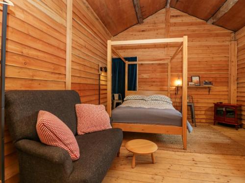 Habitación con cama y sofá en una cabaña en Dog Crag Cabin, en Millom