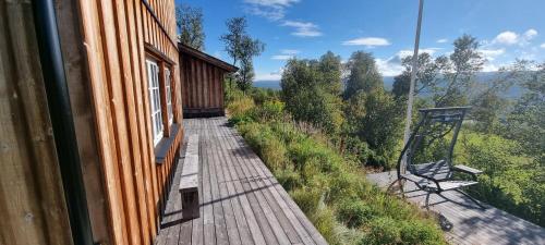 a wooden walkway next to a building with a bench at Sunny and beautiful cabin in Geilo in Geilo