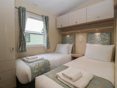 um quarto de hotel com duas camas e uma janela em Mallard em Leominster