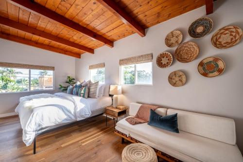een slaapkamer met een bed, een bank en ramen bij Cozy Private Beach House - Steps from the beach in Oceanside