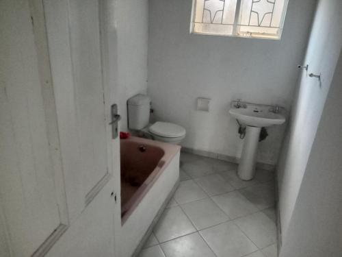 y baño con bañera, aseo y lavamanos. en Las Palmas Day & Night Guest House, en Pretoria