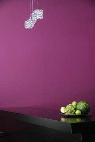 a plate of fruit on a table with a purple wall at Anessis in Thessaloniki