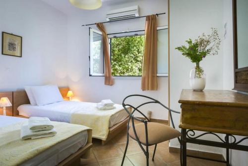 MousataにあるVilla Thalia Sofiaのベッドルーム1室(ベッド2台、椅子、窓付)