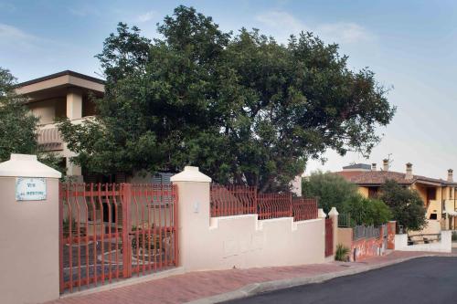 a white fence in front of a house with a tree at Casa Marzane in Cala Gonone