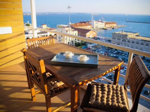 a wooden table and chairs on a balcony with a view at cloud9-skg in Thessaloniki