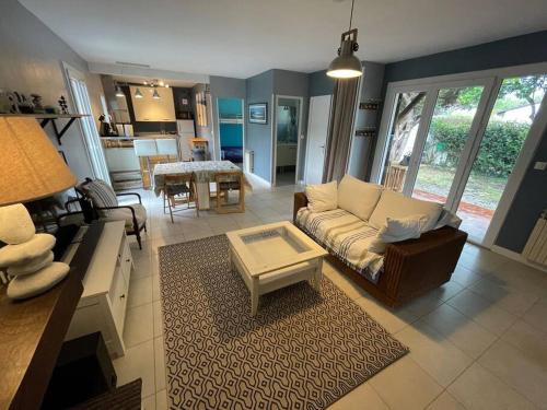 un salon avec un canapé et une table dans l'établissement Maison Indépendante Bass Arcachon 10min pied plage, à Arès