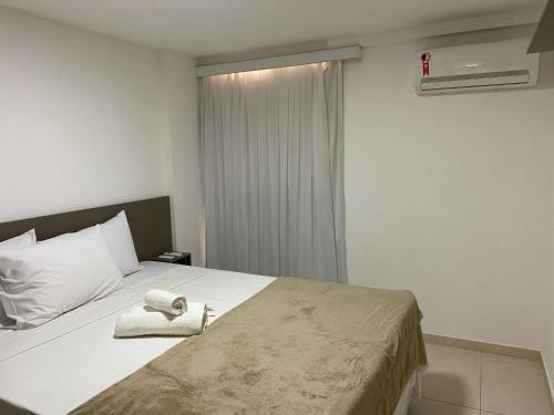 1 dormitorio con 1 cama con 2 toallas en Bela Hospedagem - EcoSummer Cobertura em Tambaú, en João Pessoa