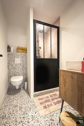 une salle de bain avec toilettes et douche en verre dans l'établissement Le petit Arth&M Clermont Ferrand, à Clermont-Ferrand
