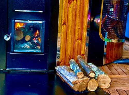 a pile of logs sitting next to a fireplace at L'insolite TAMIA in Asperjoc
