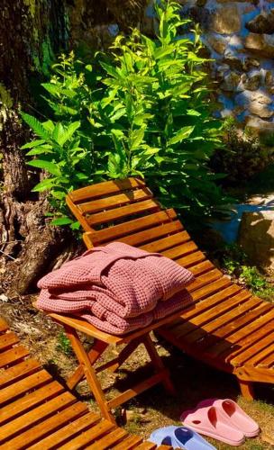 a wooden bench with a blanket on top of it at L'insolite TAMIA in Asperjoc