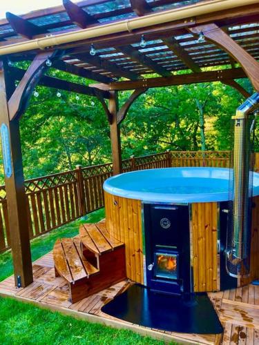a wooden pergola with a hot tub in a yard at L'insolite TAMIA in Asperjoc