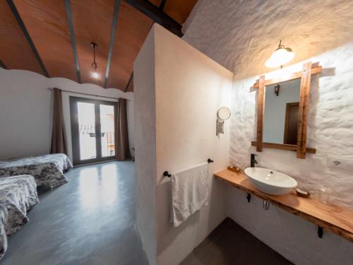 a bathroom with a sink and a bed and a mirror at Casa Rural El Palomeque 