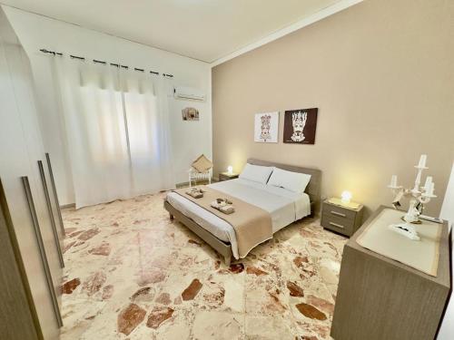 a bedroom with a large bed and a table at Da Turiddu - Aeroporto Falcone Borsellino in Cinisi