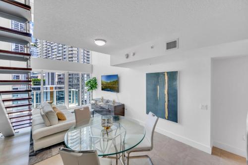 a living room with a glass table and a couch at Stunning 1 Bedroom Loft in The Heart of Brickell in Miami