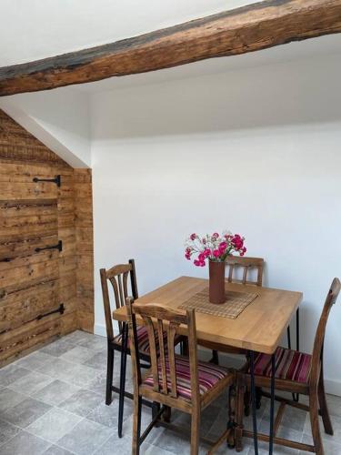 a wooden table with chairs and a vase of flowers on it at Stylish 3 bedroom apartment in historic city centre building in Sheffield