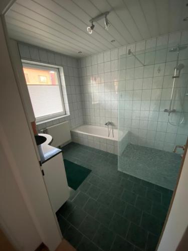 a bathroom with a shower and a tub and a toilet at Haus Anton 