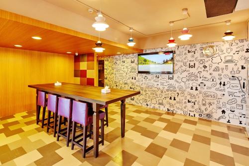 a dining room with a table and a wall covered in graffiti at Single Inn - Taipei in Taipei
