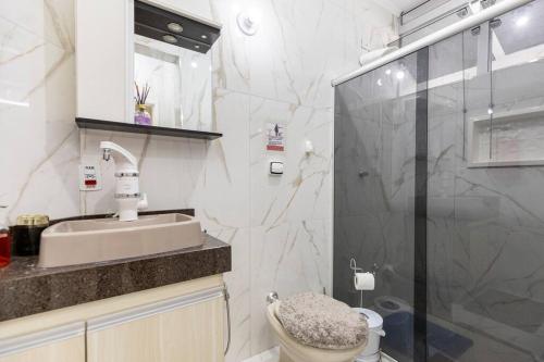 a bathroom with a shower and a sink and a toilet at Apartamento no centro. Tudo novinho, aconchegante in Águas de Lindóia