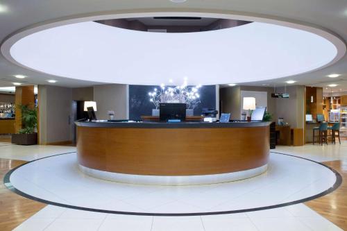 a large lobby with a reception desk in a building at Dolce by Wyndham Milan Malpensa in Somma Lombardo