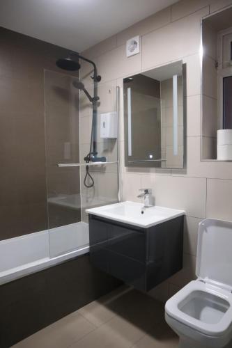 uma casa de banho com um lavatório, um chuveiro e um WC. em Park view apartment em Manchester
