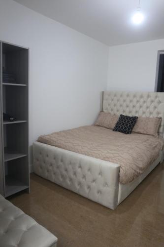 1 cama blanca en una habitación blanca con vistas a las faldas en Park view apartment en Mánchester