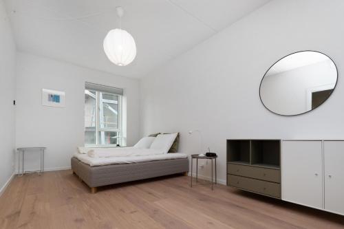 a white living room with a couch and a mirror at Come Stay Close To Nyhavn - CPH's Best View in Copenhagen