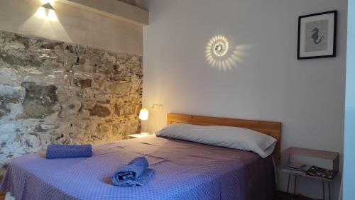 1 dormitorio con cama y pared de piedra en VALDEVAQUEROS HOUSE, en Tarifa
