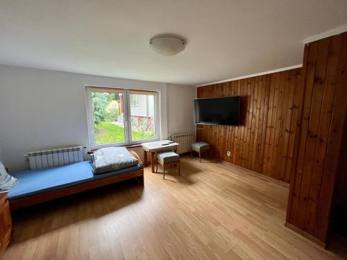 sypialnia z łóżkiem i telewizorem z płaskim ekranem w obiekcie Domek na Mazurach niedaleko jeziora w Piszu
