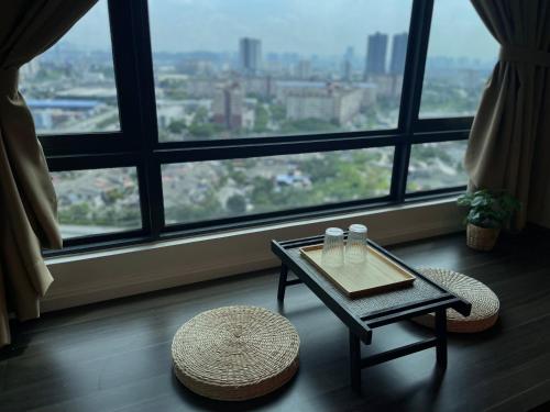 a table and chairs in a room with a large window at Greenfield Residence, Bandar Sunway by The Comfort Zone in Petaling Jaya