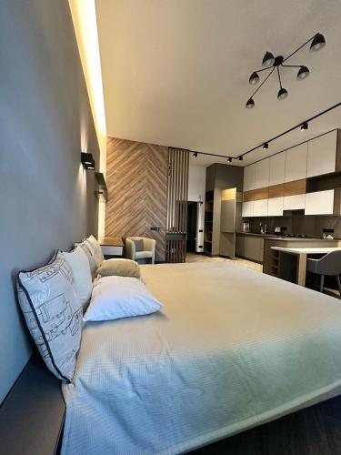 a bedroom with a large bed and a kitchen at Duke Apartments in Odesa
