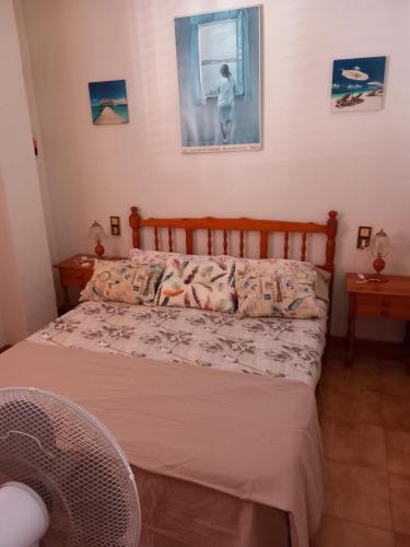 a bedroom with a bed and a picture on the wall at Apartamento Santa Pola, en Playa del Tamarit con piscina. in Santa Pola