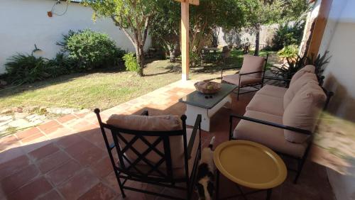 un patio con sillas, un sofá y una mesa en VALDEVAQUEROS HOUSE, en Tarifa