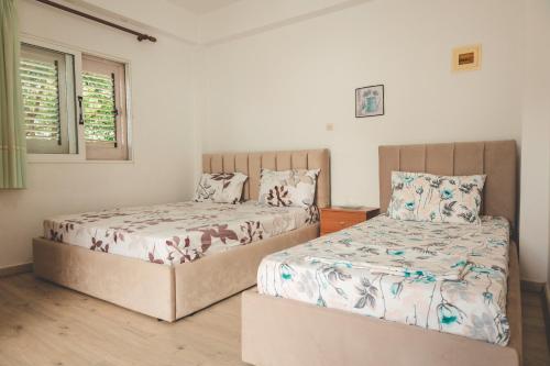 twee bedden naast elkaar in een slaapkamer bij Rooms by the sea in Himare