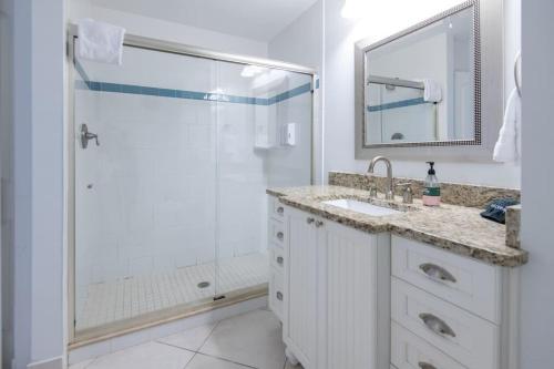 a bathroom with a shower and a sink and a mirror at Secluded Beachfront Vibes - Surf & Pet Friendly in Fort Pierce