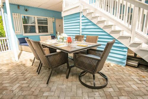 a dining table and chairs on a patio at Secluded Beachfront Vibes - Surf & Pet Friendly in Fort Pierce