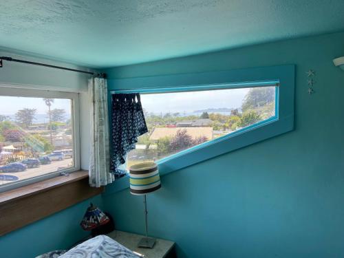 1 dormitorio con una pared azul y una ventana en 1 Belvedere Ave, en Stinson Beach