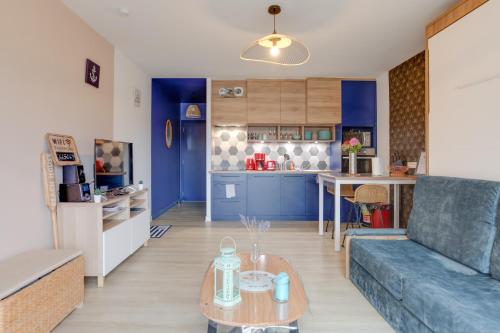 ein Wohnzimmer mit einem blauen Sofa und einem Tisch in der Unterkunft Gîte des randonneurs de la Presqu'île de Lézardrieux Bretagne in Lézardrieux