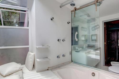 y baño con ducha acristalada y lavamanos. en Ibirapuera Park House en São Paulo