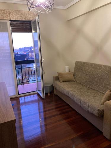 sala de estar con sofá y ventana grande en Ontziola - ONGI ETORRI en Zumaia