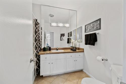 洛杉磯的住宿－Beverly Hills Glamour Oasis 2 BR Apt with Parking 304，一间带水槽和镜子的浴室