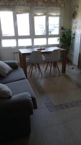 sala de estar con sofá, mesa y sillas en Ontziola - ONGI ETORRI en Zumaia